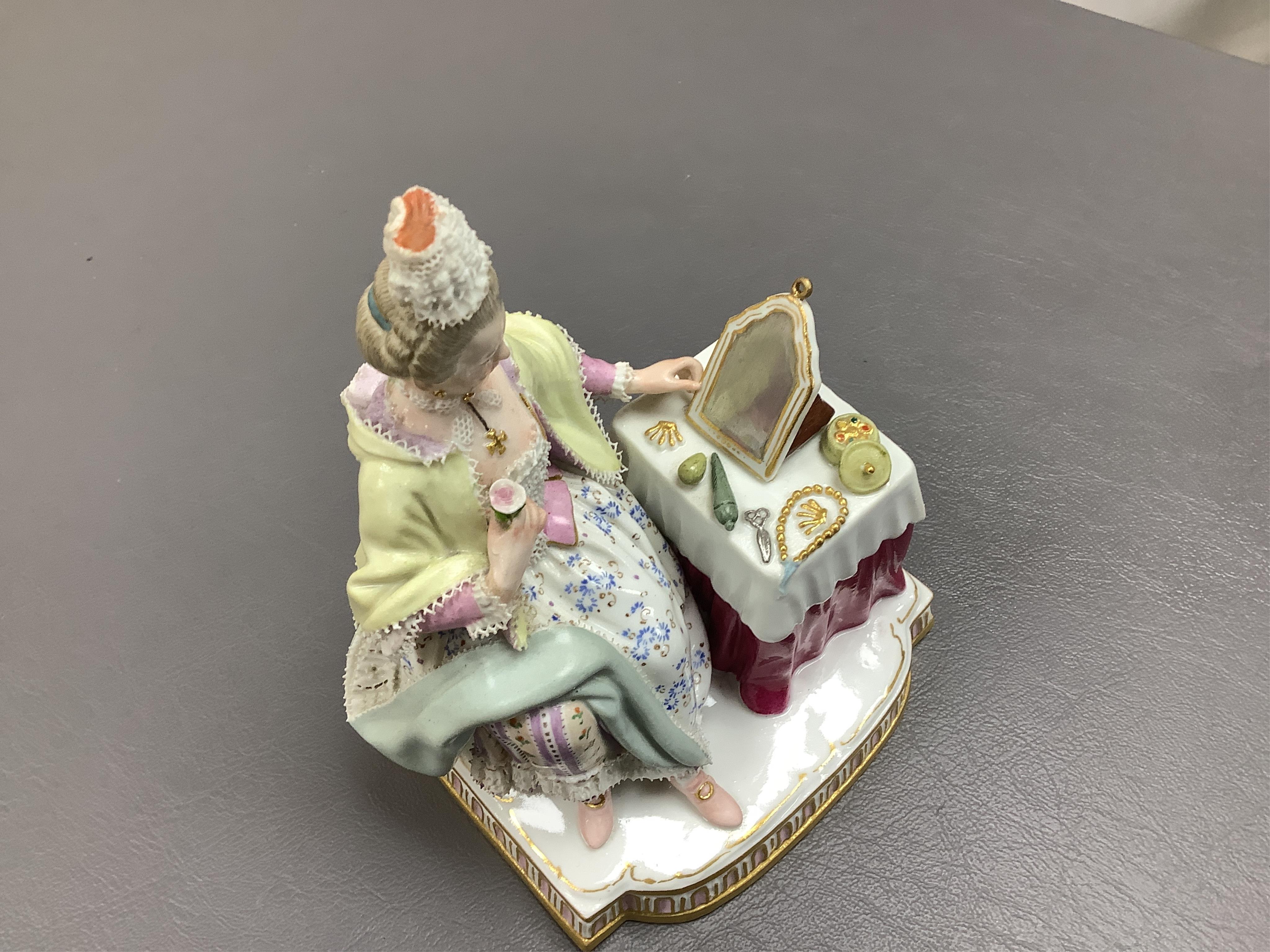 A late 19th century Meissen figure of Sight, from the Senses, a seated lady at her dressing table, crossed swords mark and incised E3 mark to base, 14cm high